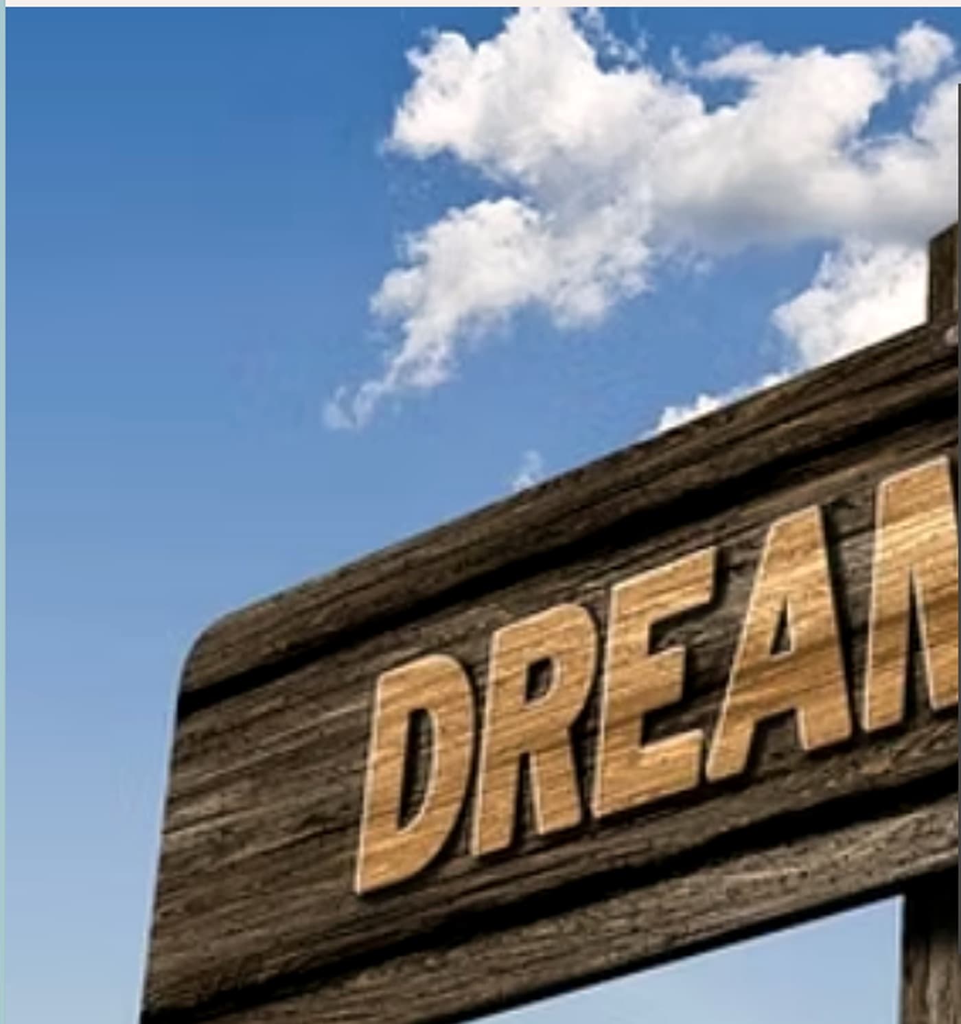A wooden signpost reading Dream against a bright blue sky.