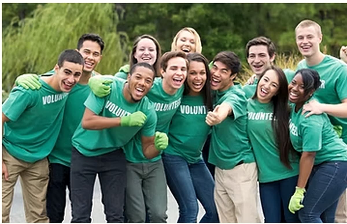 A group of SIWD volunteers in matching shirts, arm in arm.
