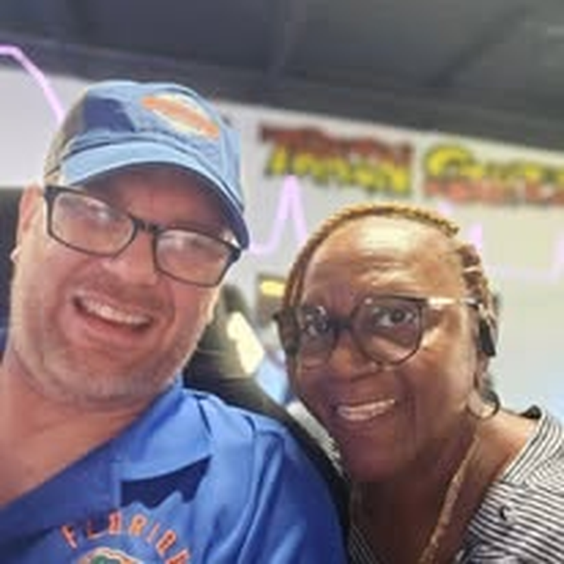 A staff member and volunteer smiling for a photo at the arcade.