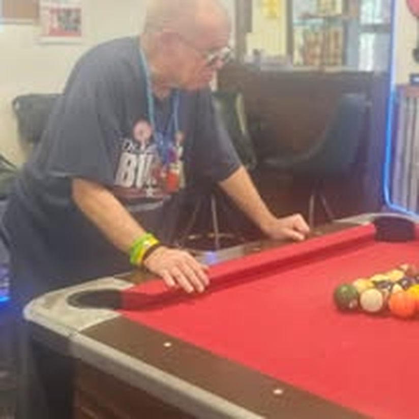 A volunteer lining up a shot during pool night.