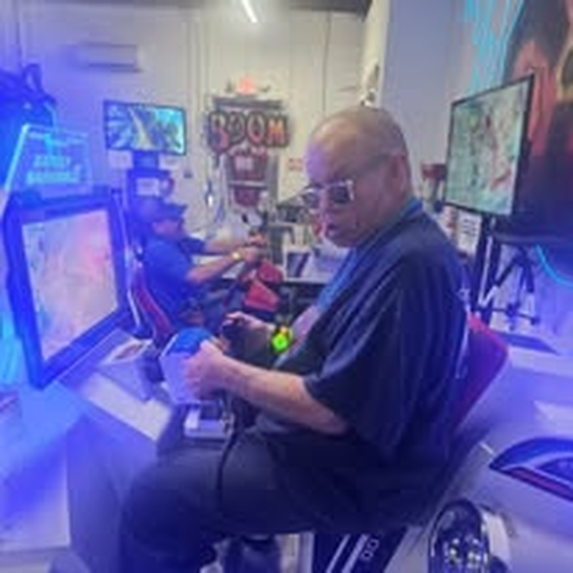A staff member enjoying a racing game at the arcade.