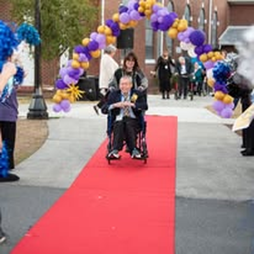 An individual in a wheelchair cheered on down the red carpet.