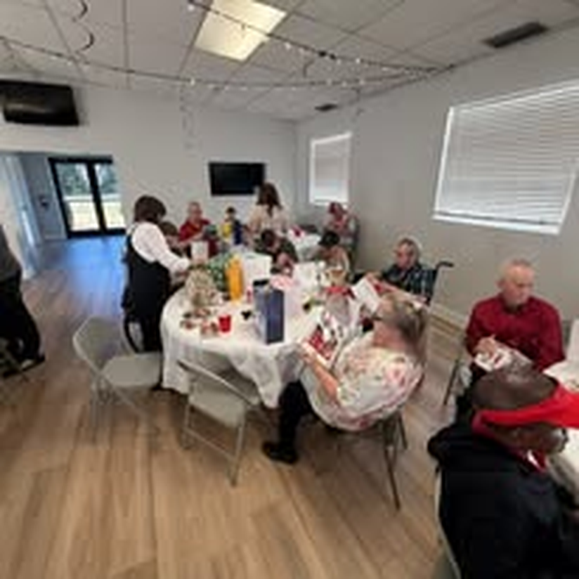 Guests enjoying a holiday feast together at long dinner tables.
