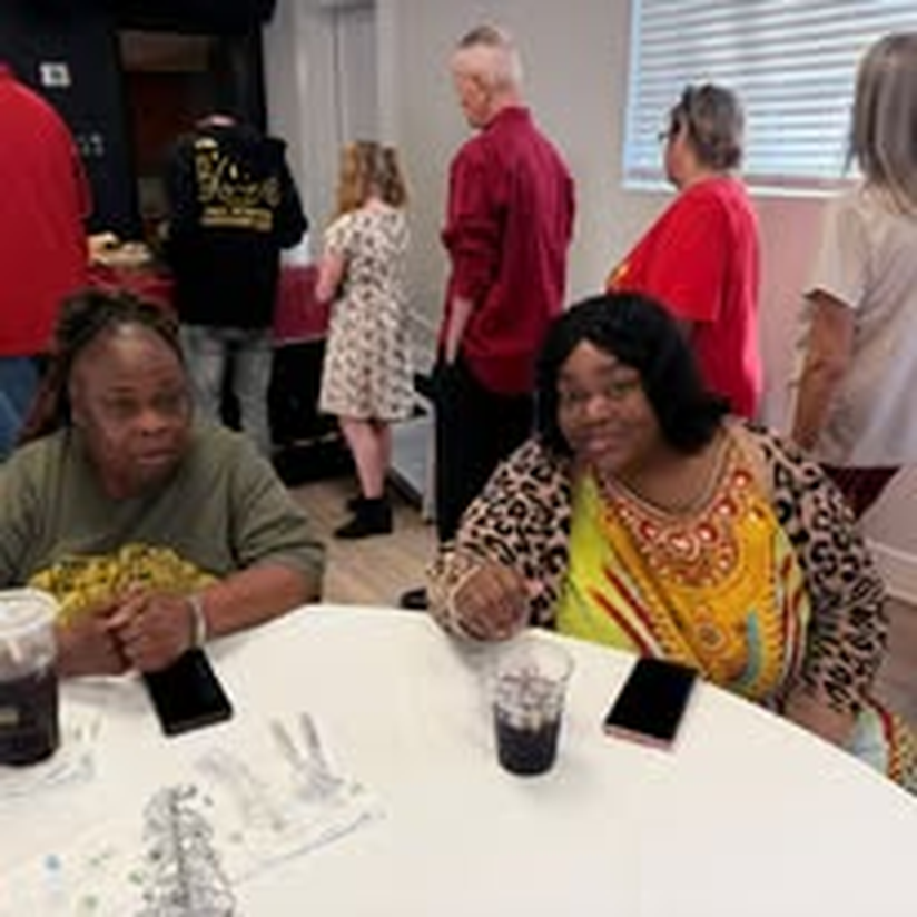 Two staff members catching up at a community event.