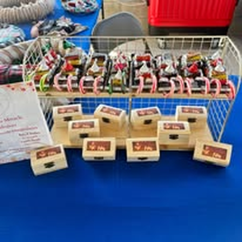 Handmade wood ornaments and crafts on display at a market table.