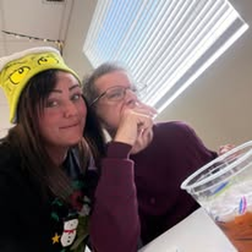 Two staff members sharing a laugh during a fun outing.