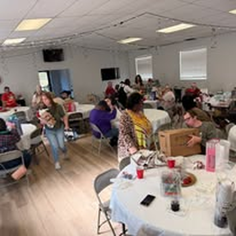 A busy room full of volunteers at a community craft workshop.
