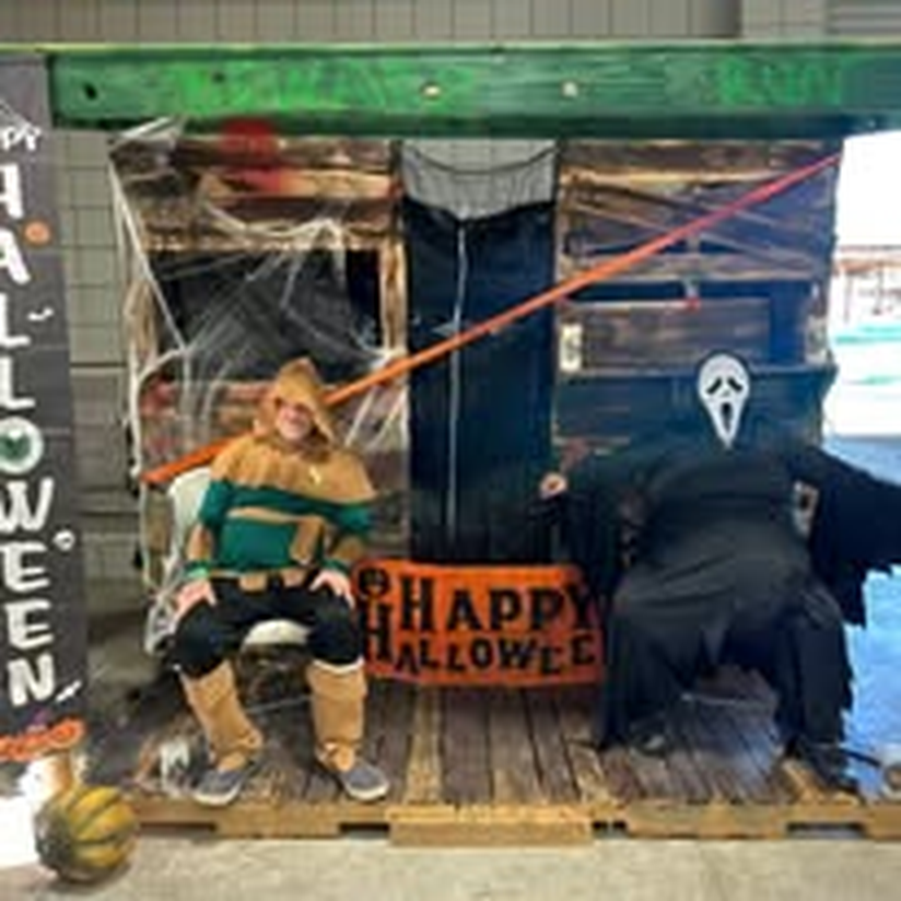 A child getting into the spooky spirit at a Halloween photo booth prop.