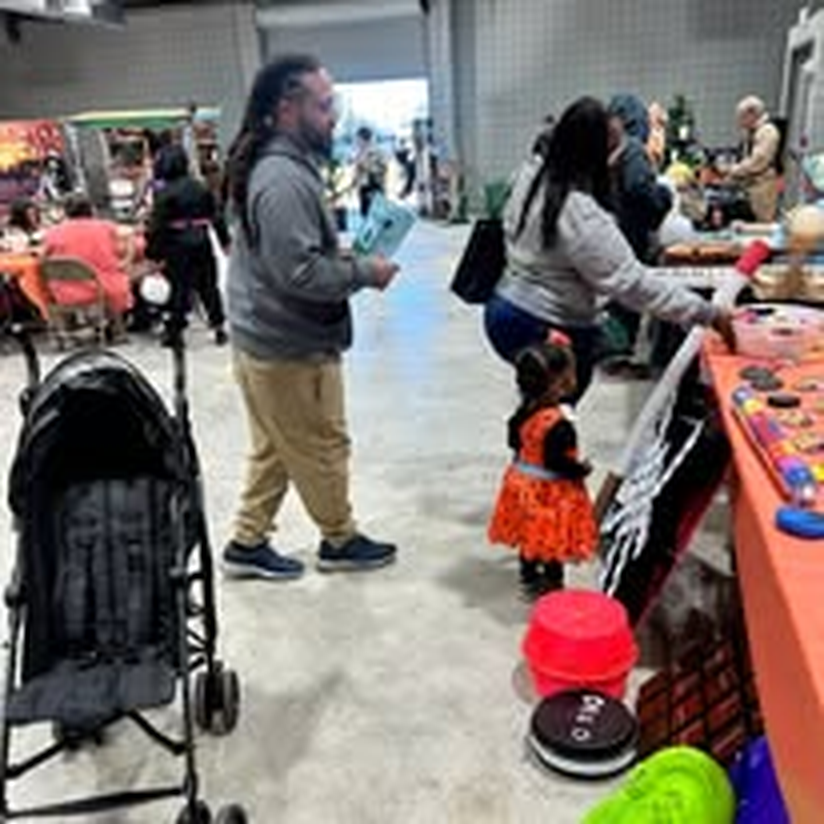 A family trick-or-treating through the vendor booths.