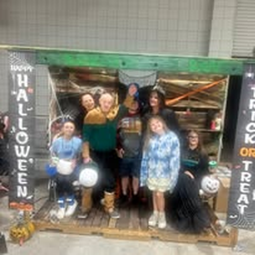 A group in costume gathered at the Halloween celebration photo booth.