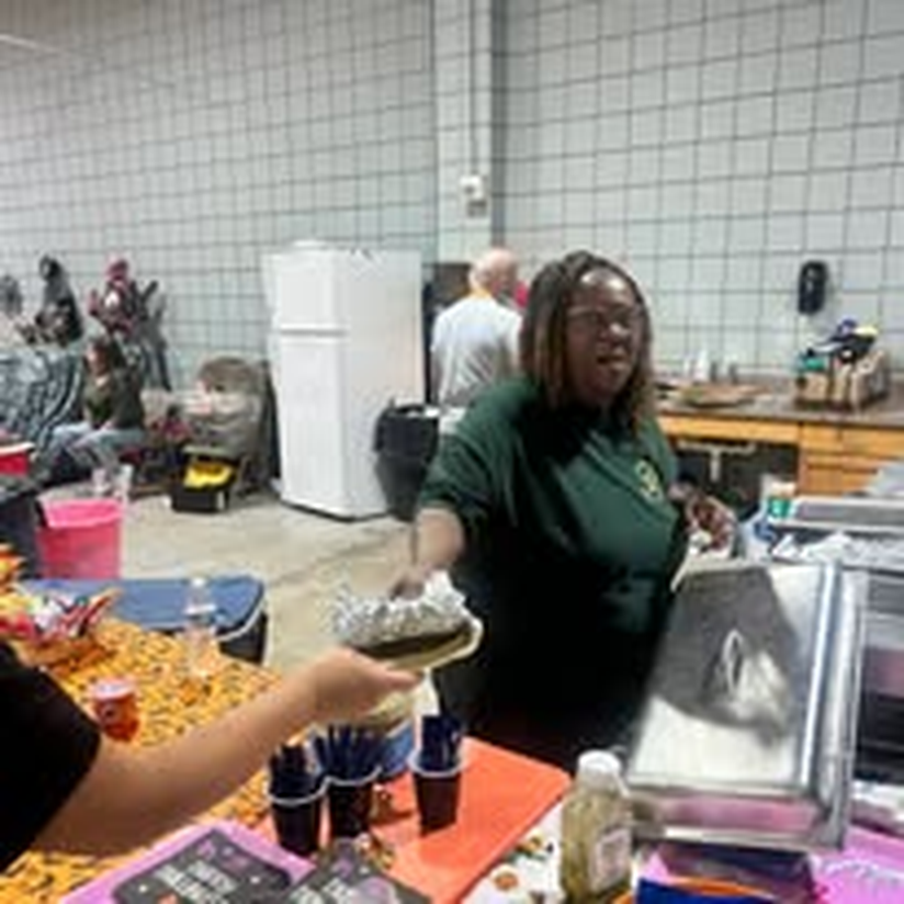 A volunteer serving cupcakes at the Halloween market.